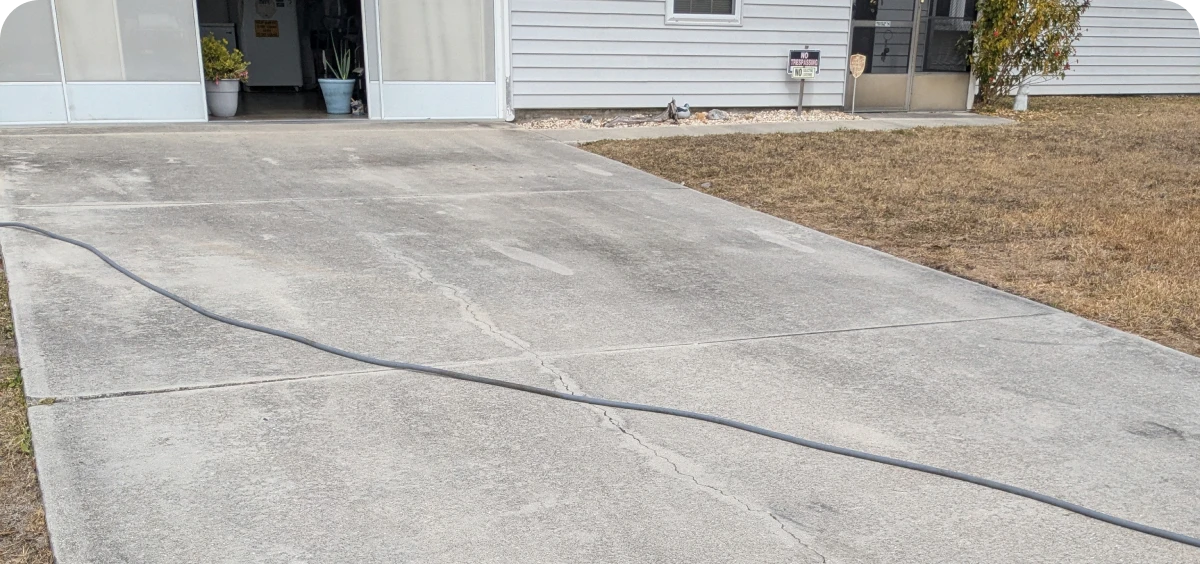 House exterior with driveway and hose